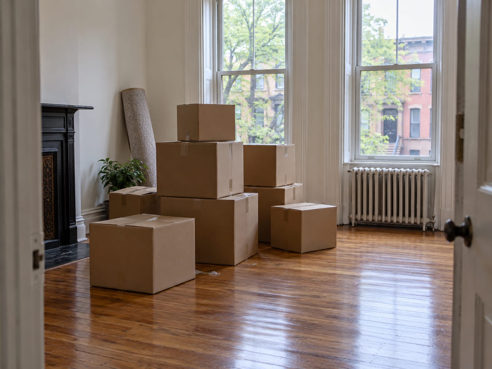 Cajas de mudanza apiladas en la sala vacía de un apartamento en una casa adosada de la ciudad