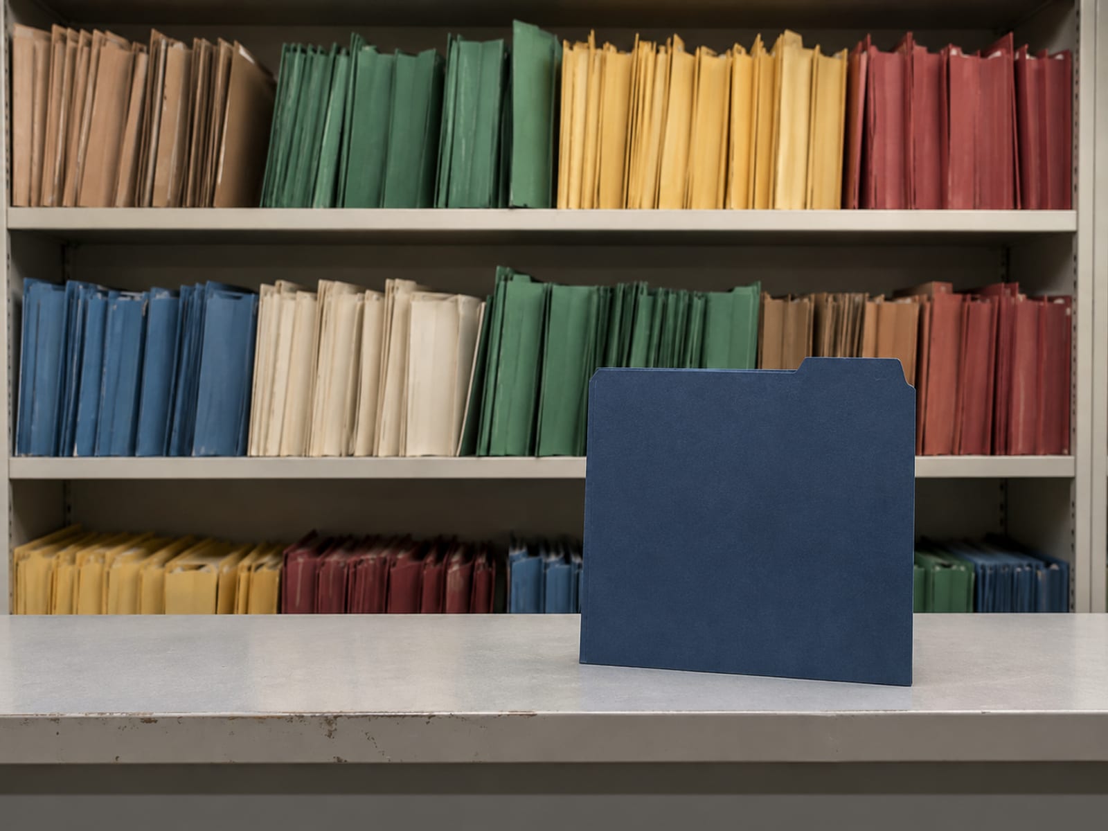 One neat folder standing apart from a shelf of many differently colored folders