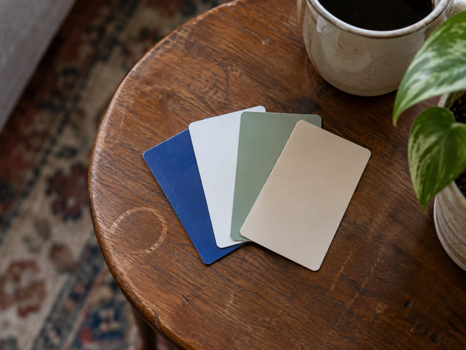 A few blank plastic member cards fanned out on a wooden table beside a pair of reading glasses