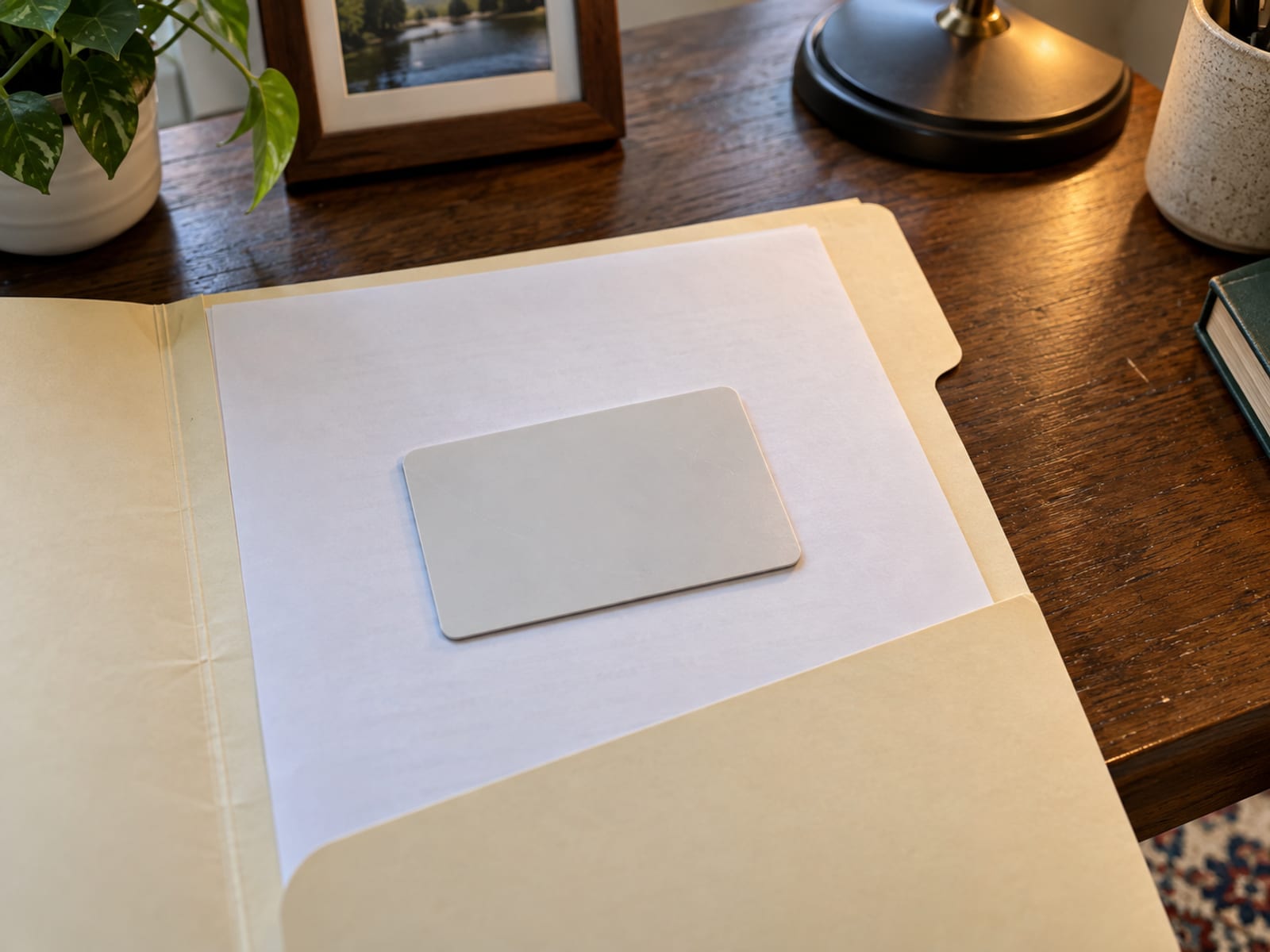 Blank plastic card with no text or logo resting on an open folder on a desk