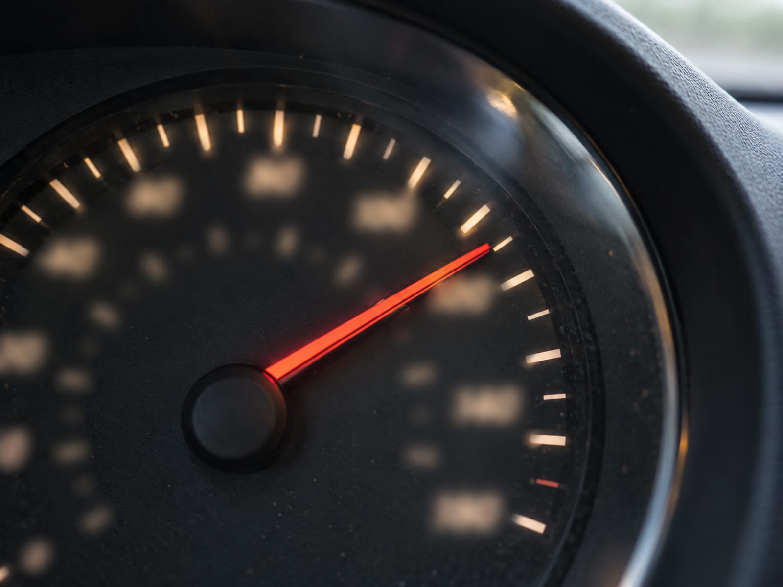 Close view of a car speedometer needle at highway speed