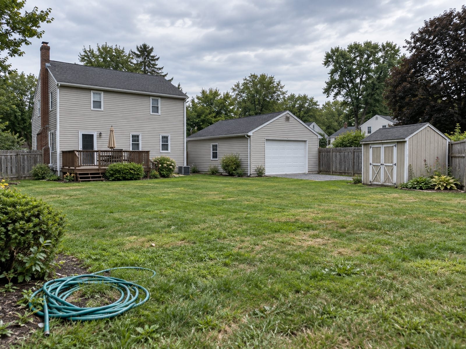 A Pennsylvania home with a detached garage, a garden shed and a wooden fence in the backyard