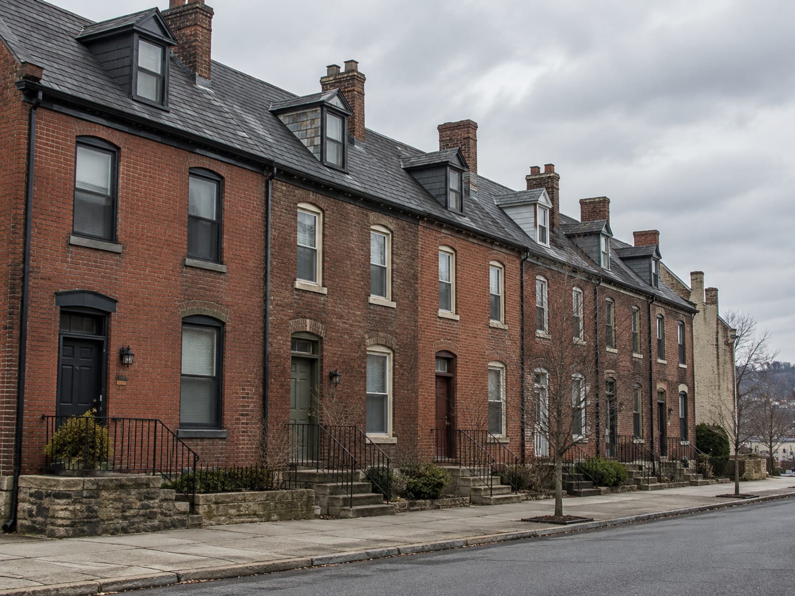 An older brick rowhouse block in a Pennsylvania town with slate roofs and chimneys