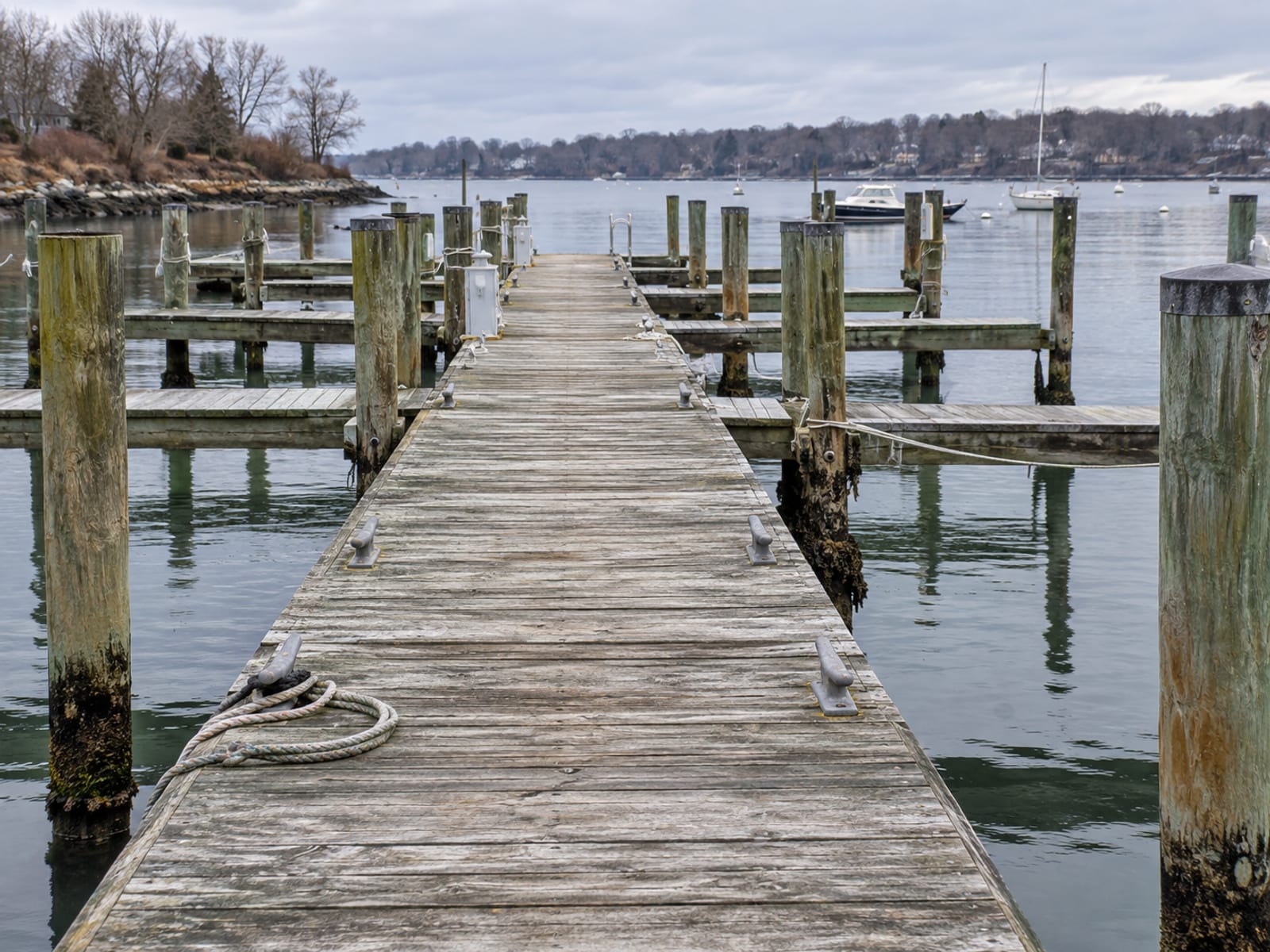 A row of empty boat slips along a wooden dock at a small marina on calm water