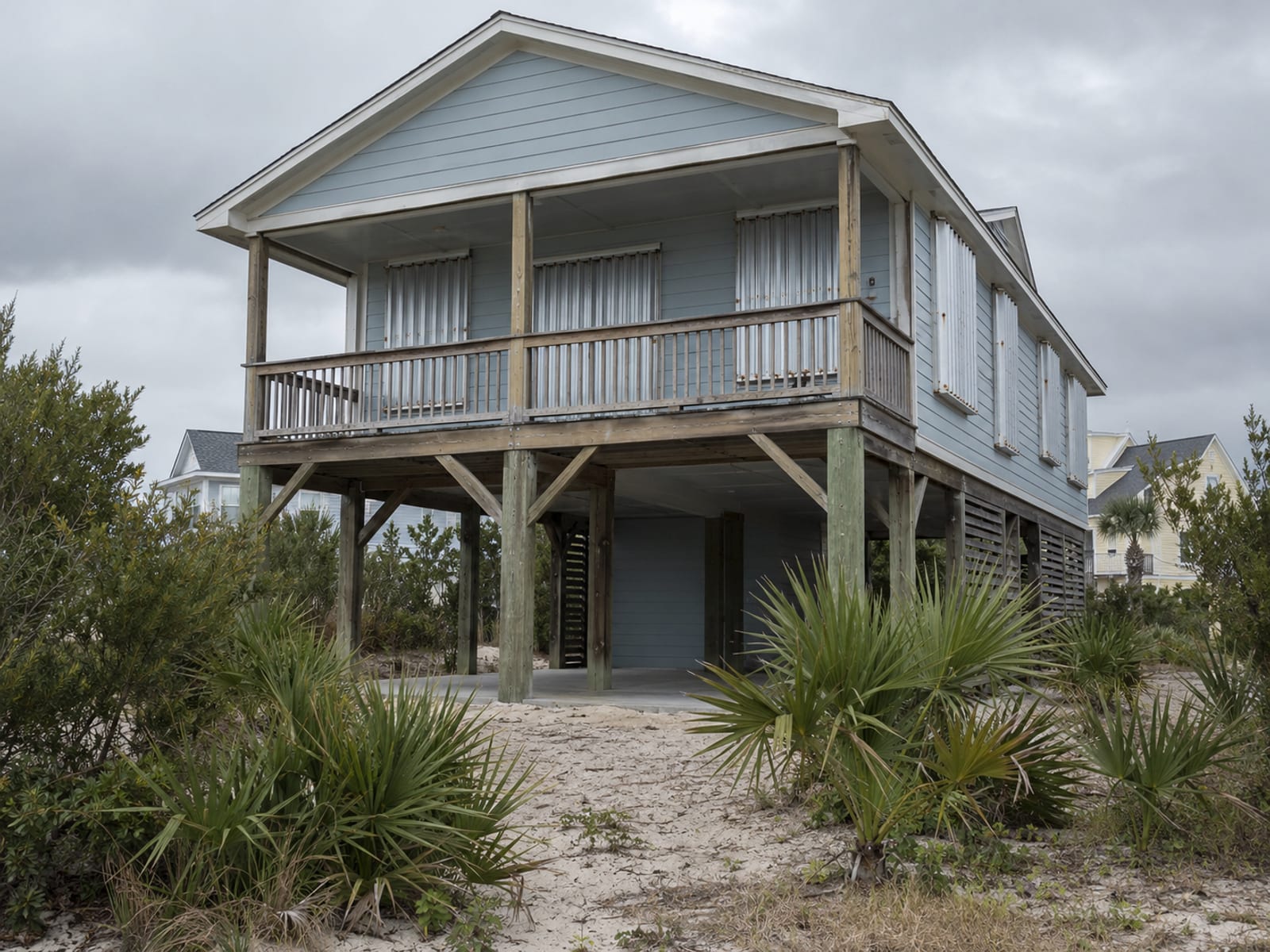 Closed metal storm shutters over the windows of a coastal home