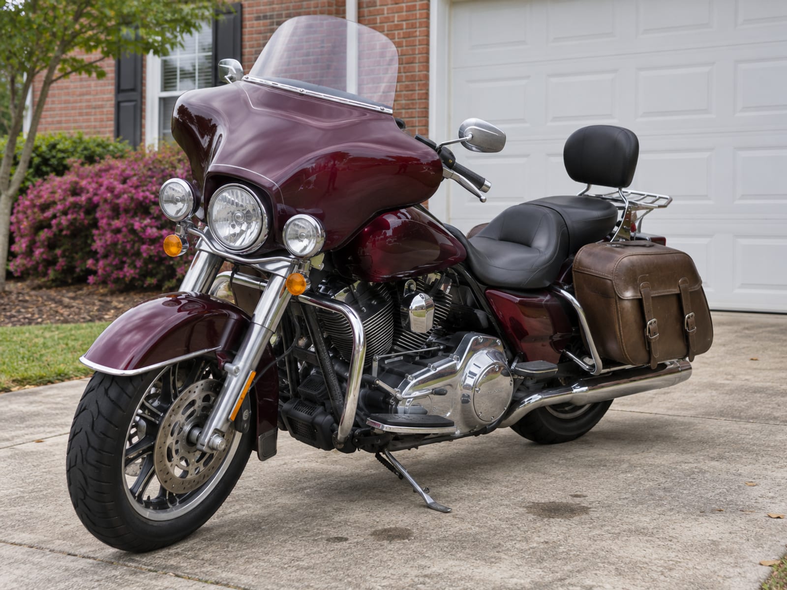 A motorcycle with saddlebags and chrome accessories parked in a home driveway