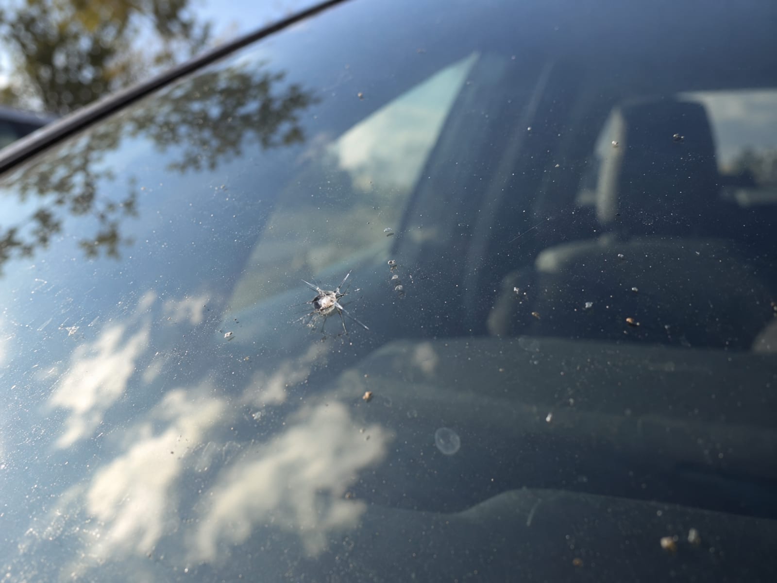 Close view of a small star-shaped chip in a car windshield